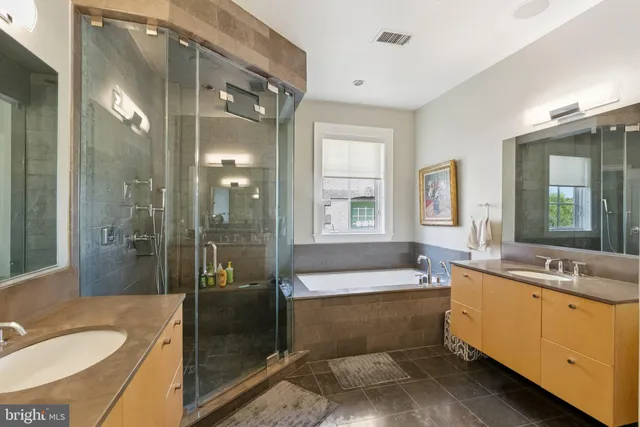 a bathroom with a tub sink shower and mirror
