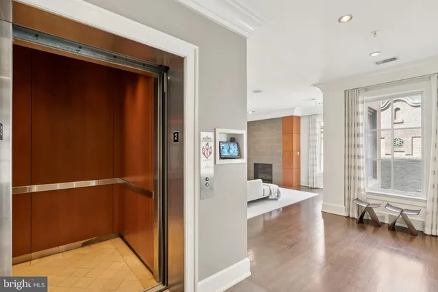 a view of a hallway with wooden floor and windows
