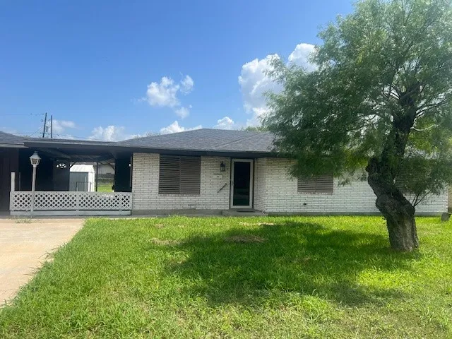 a view of a yard in front of a house with large trees