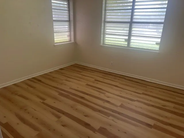 a view of a room with wooden floor and window
