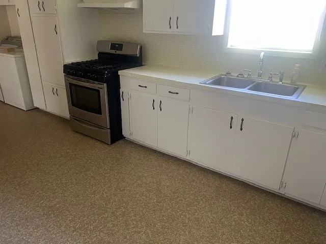 a kitchen with a sink stove and cabinets
