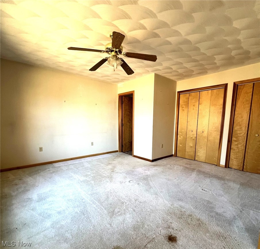 46292 Cedar Way Rogers, OH 44455 - Photo 9 of 12 Unfurnished bedroom with multiple closets, light carpet, and ceiling fan