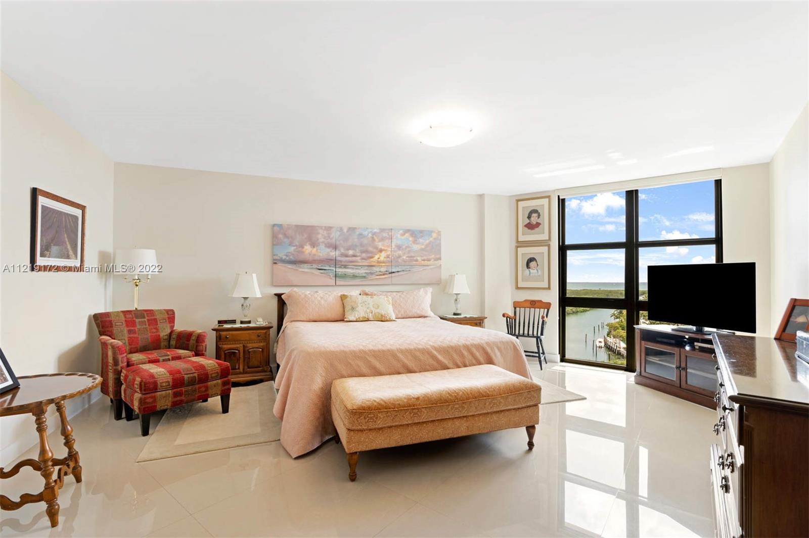 1121 Crandon Boulevard, Unit E801 Key Biscayne, FL 33149 - Photo 12 of 29 a bedroom with a bed a couch and a flat screen tv