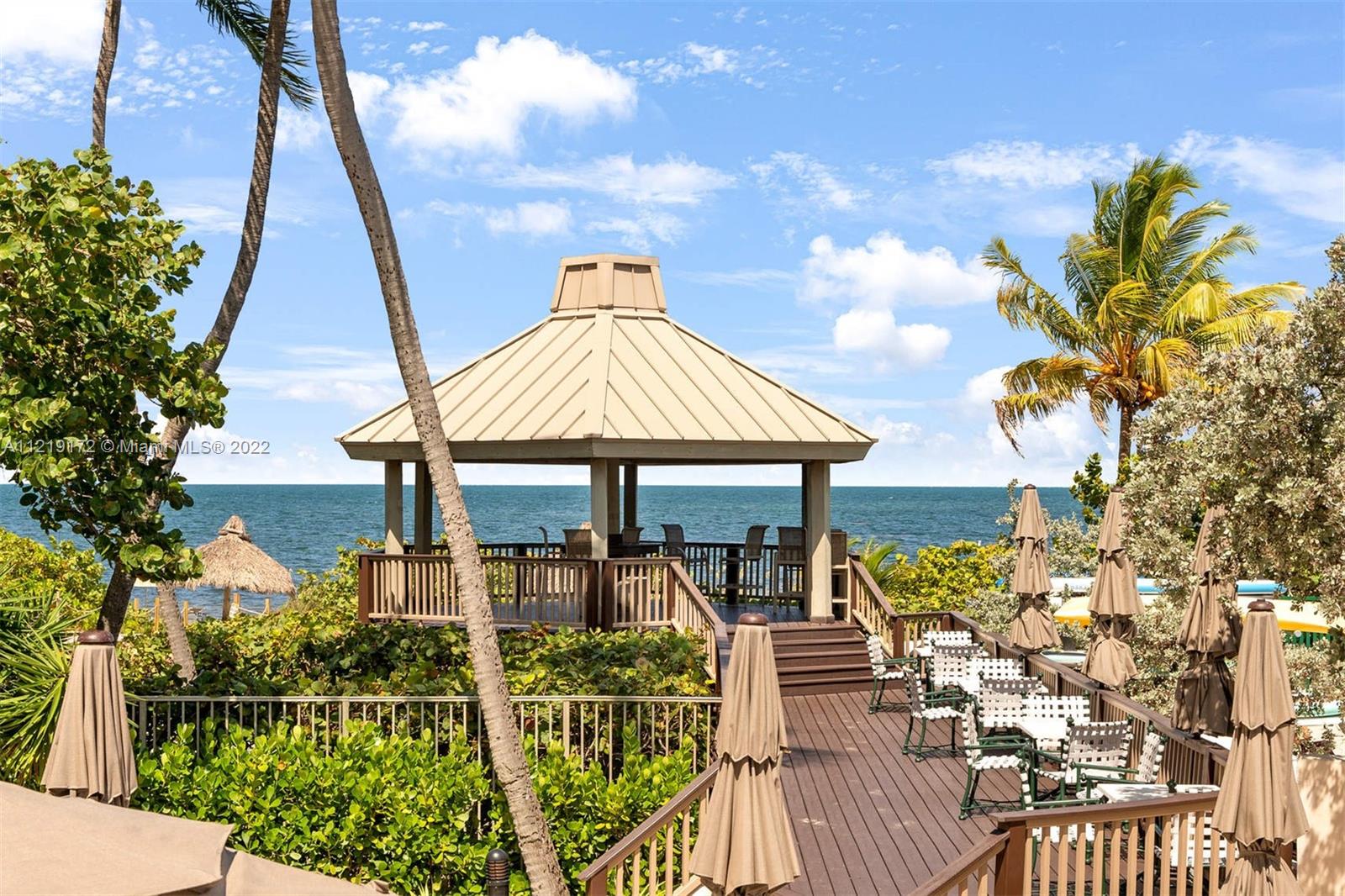 1121 Crandon Boulevard, Unit E801 Key Biscayne, FL 33149 - Photo 25 of 29 a front view of a house with wooden floor fence and a table