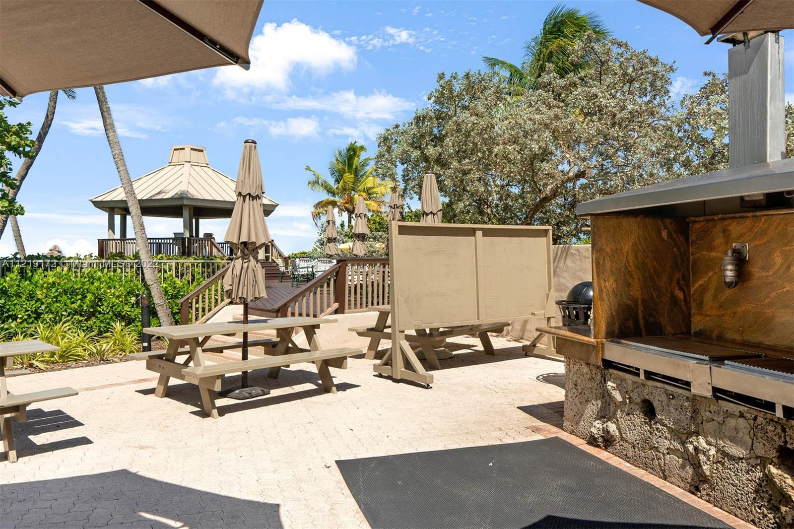 1121 Crandon Boulevard, Unit E801 Key Biscayne, FL 33149 - Photo 28 of 29 a view of a patio with table and chairs under an umbrella