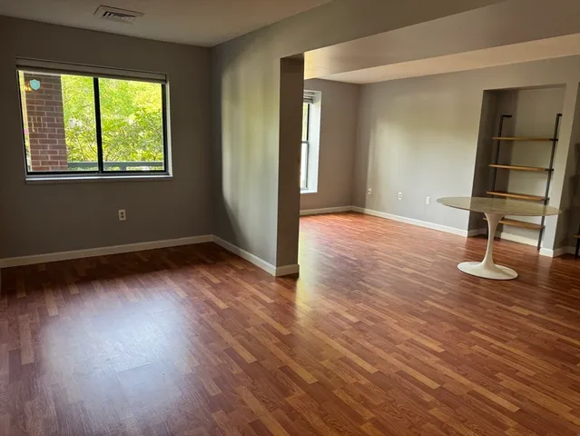 a view of empty room with wooden floor and window