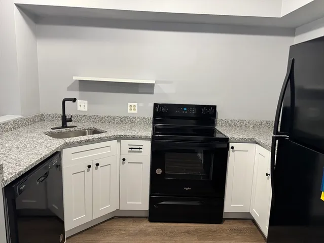 a kitchen with granite countertop a refrigerator and a stove