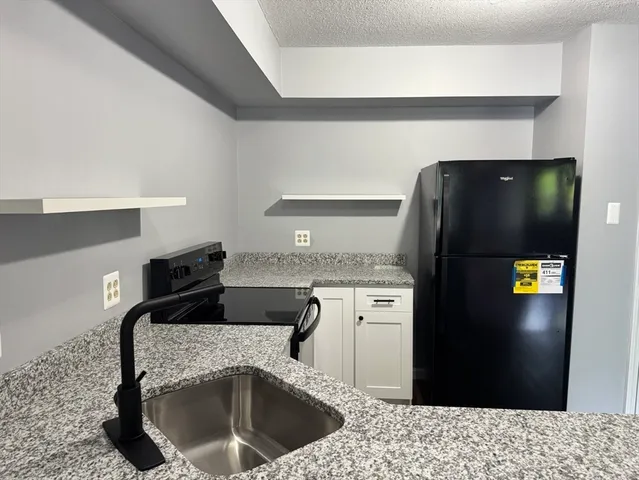 a kitchen with a refrigerator and a sink