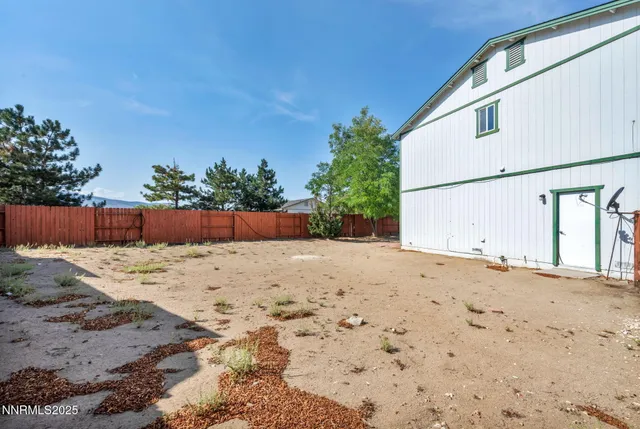 a backyard of a house with barbeque oven and trees