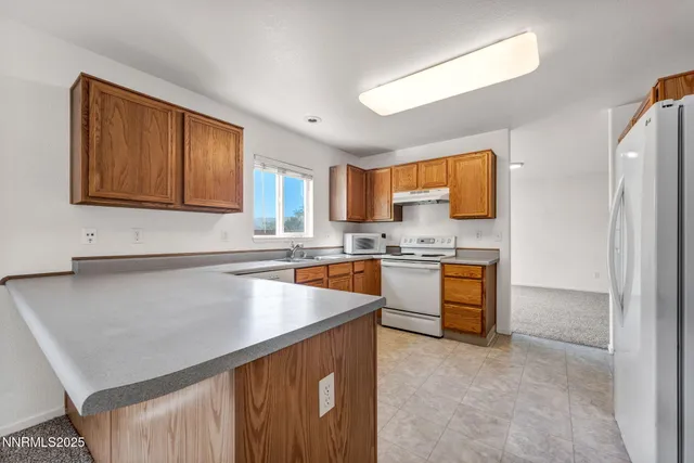 a kitchen with stainless steel appliances granite countertop a sink refrigerator stove microwave and cabinets