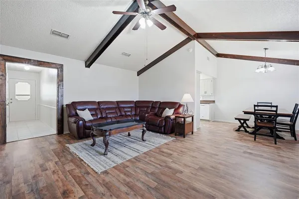 a living room with furniture and a wooden floor
