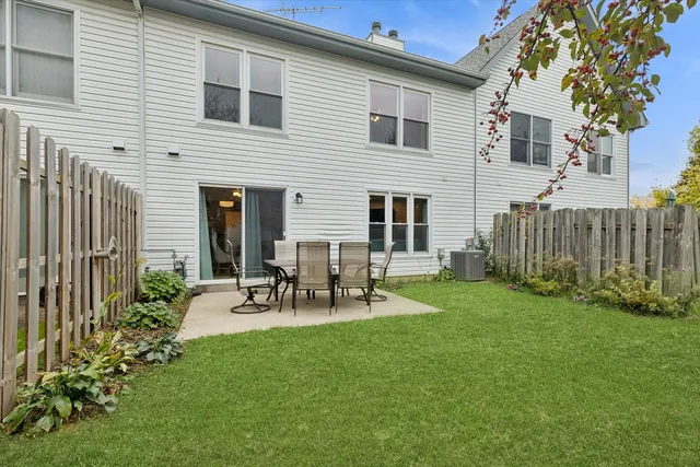 a view of a patio with table and chairs with wooden fence