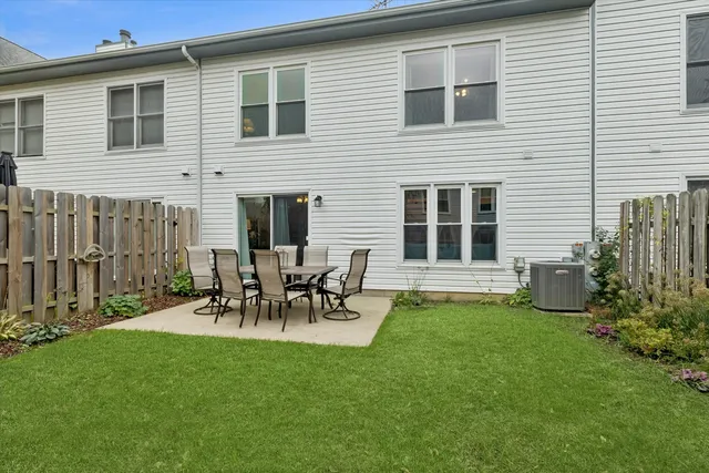 a view of a chair and table in backyard of the house