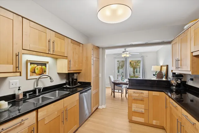 a large kitchen with granite countertop a sink stainless steel appliances and cabinets