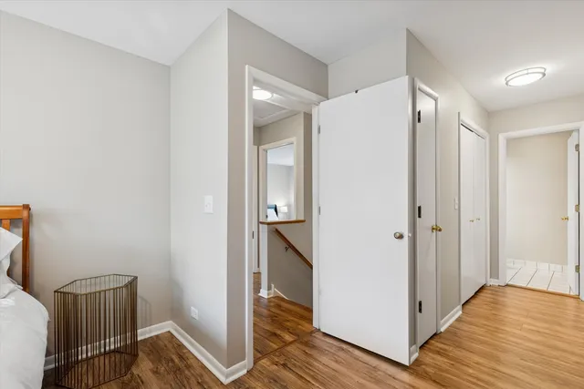 a view of a hallway with wooden floor and a bathroom
