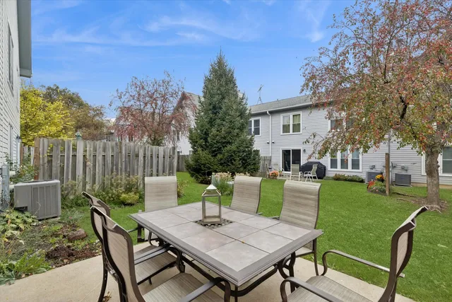 a view of a patio with a table chairs and a fire pit
