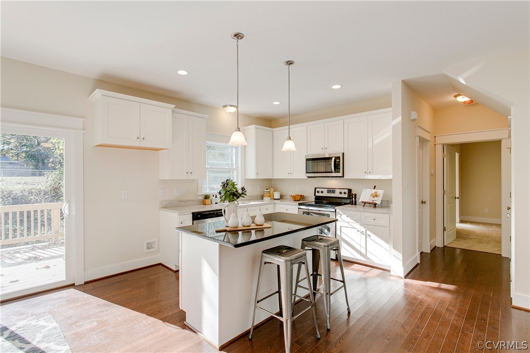 15812 Harrowgate Road Chester, VA 23831 - Photo 6 of 31 a kitchen with stainless steel appliances kitchen island granite countertop a stove a sink a refrigerator and a microwave