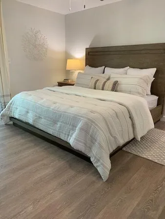 a bedroom with a bed and wooden floor