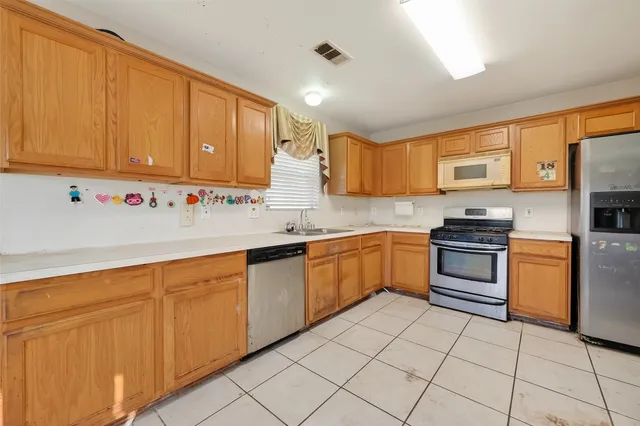 a kitchen with granite countertop a sink stainless steel appliances and cabinets