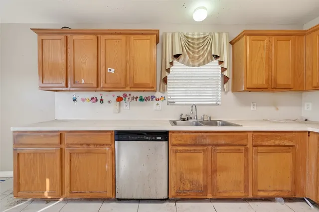 a kitchen with granite countertop wooden cabinets and a sink