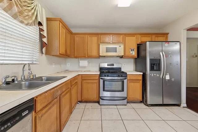 a kitchen with stainless steel appliances granite countertop a refrigerator sink and stove