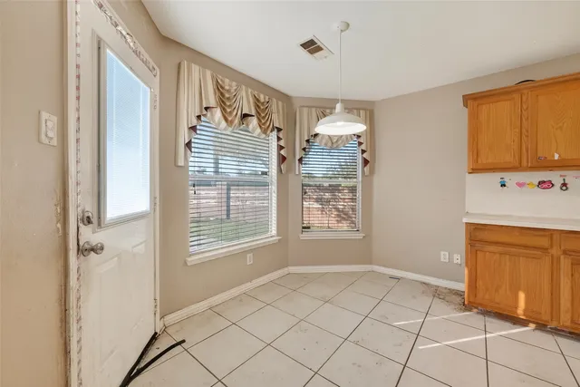 a view of an empty room with window and cabinet
