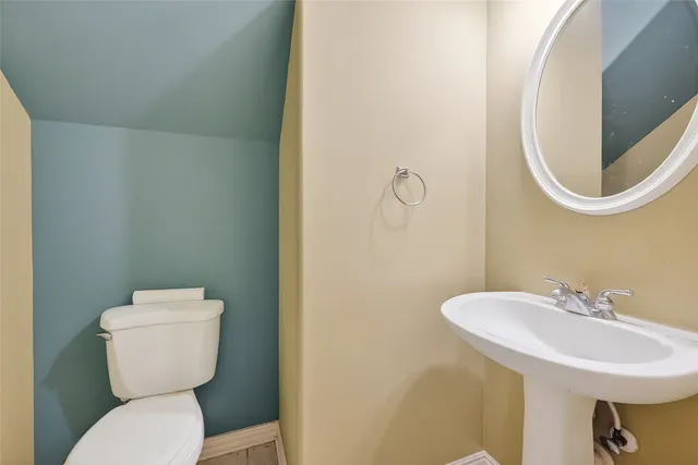 a bathroom with a toilet sink and mirror