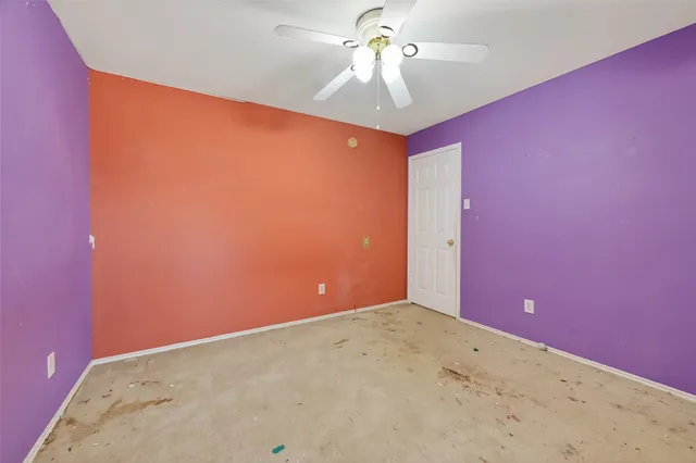 en empty room with windows and fan