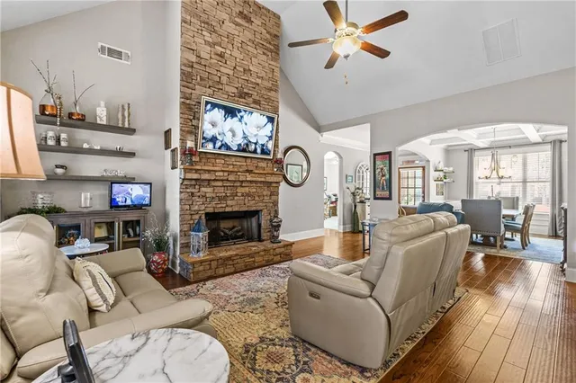 a kitchen with stainless steel appliances granite countertop a stove top oven a refrigerator a sink and chairs