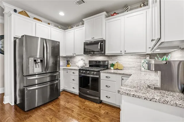 a living room with furniture kitchen view and a wooden floor