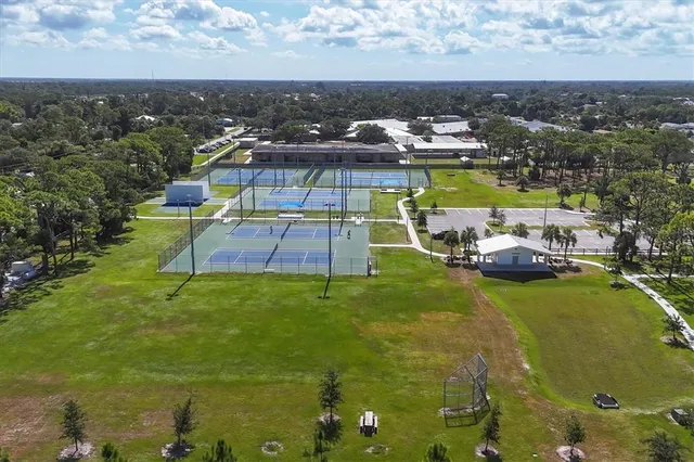 a view of a patio with table and chairs potted plants and palm tree