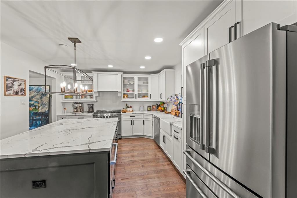603 Highland Ridge Road Claysville, PA 15323 - Photo 15 of 47 a kitchen with stainless steel appliances a refrigerator a sink dishwasher a stove and white cabinets with wooden floor
