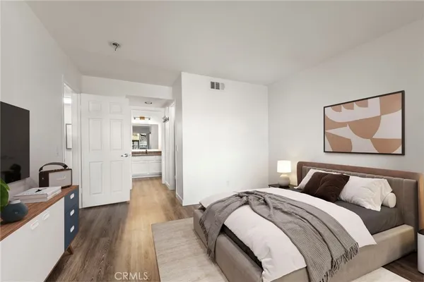 a bedroom with a bed and a painting on the wall