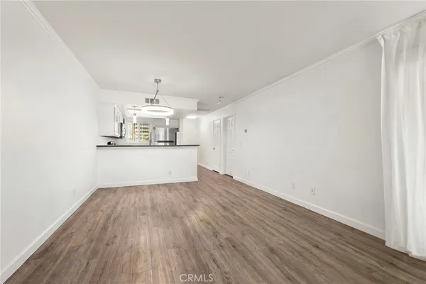 a view of a kitchen with wooden floor and stainless steel appliances