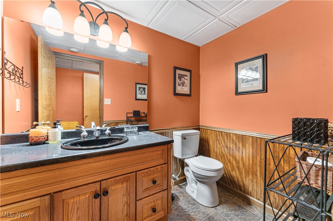 155 Ridgewood Boulevard Belpre, OH 45714 - Photo 31 of 49 Bathroom with vanity, a wainscoted wall, wooden walls, and an ornate ceiling