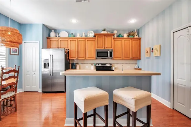 a kitchen with stainless steel appliances a stove a sink a microwave a refrigerator and cabinets