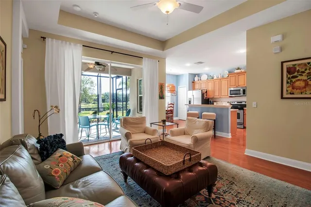 a kitchen with stainless steel appliances granite countertop a stove a sink a microwave a dining table and chairs with wooden floor