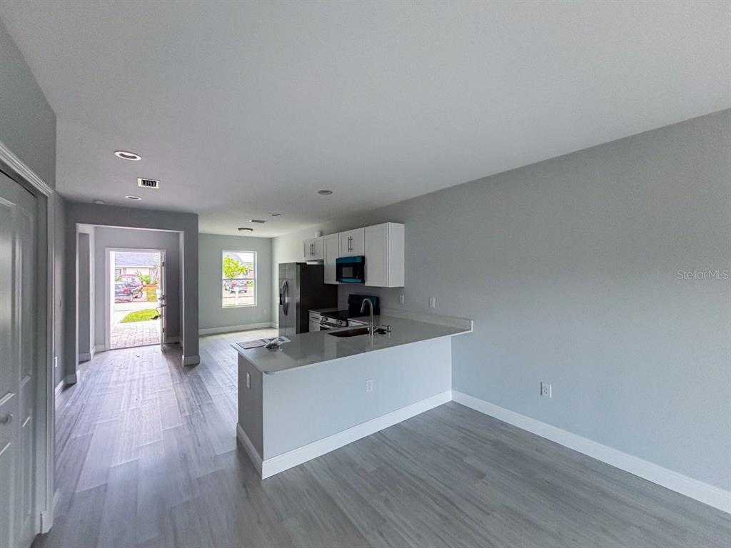 17046 Byron Avenue, Unit 17048 Port Charlotte, FL 33954 - Photo 2 of 8 a living room with a couch and a chandelier