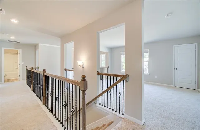 a view of a hallway with mirror and stairs