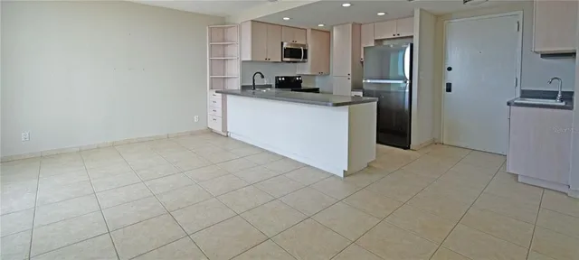 a kitchen with stainless steel appliances granite countertop a refrigerator and a stove top oven