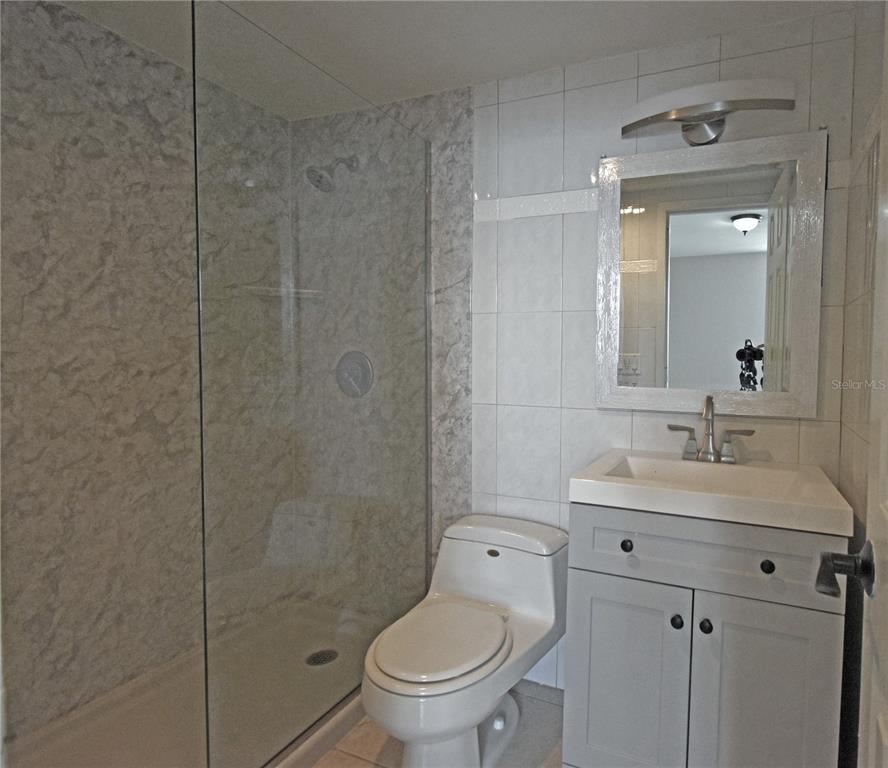 4015 Bayshore Boulevard, Unit 17F Tampa, FL 33611 - Photo 26 of 32 a bathroom with a toilet sink vanity and mirror
