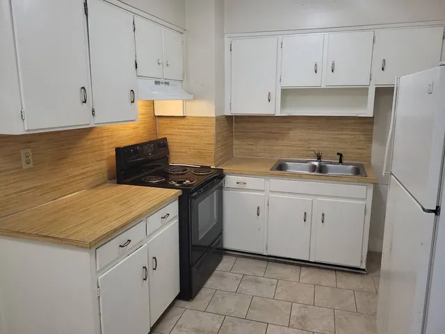 a kitchen with white cabinets sink and white appliances