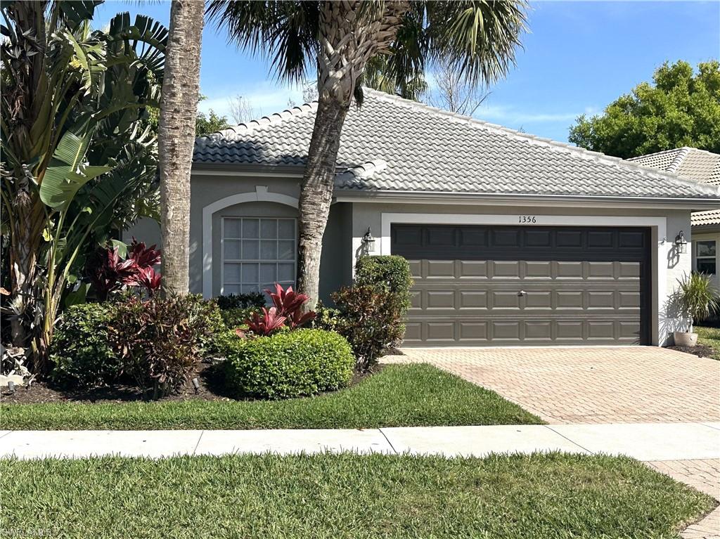 1356 Triandra Lane Naples, FL 34119 - Photo 1 of 38 a front view of a house with a yard and garage