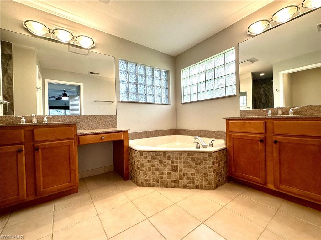 1356 Triandra Lane Naples, FL 34119 - Photo 18 of 38 a spacious bathroom with a tub sink and mirror