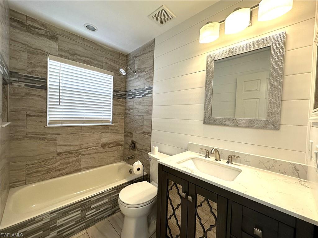 1356 Triandra Lane Naples, FL 34119 - Photo 23 of 38 a bathroom with a sink a toilet a mirror and bathtub