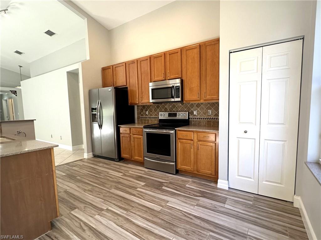 1356 Triandra Lane Naples, FL 34119 - Photo 9 of 38 a kitchen with a refrigerator sink and microwave