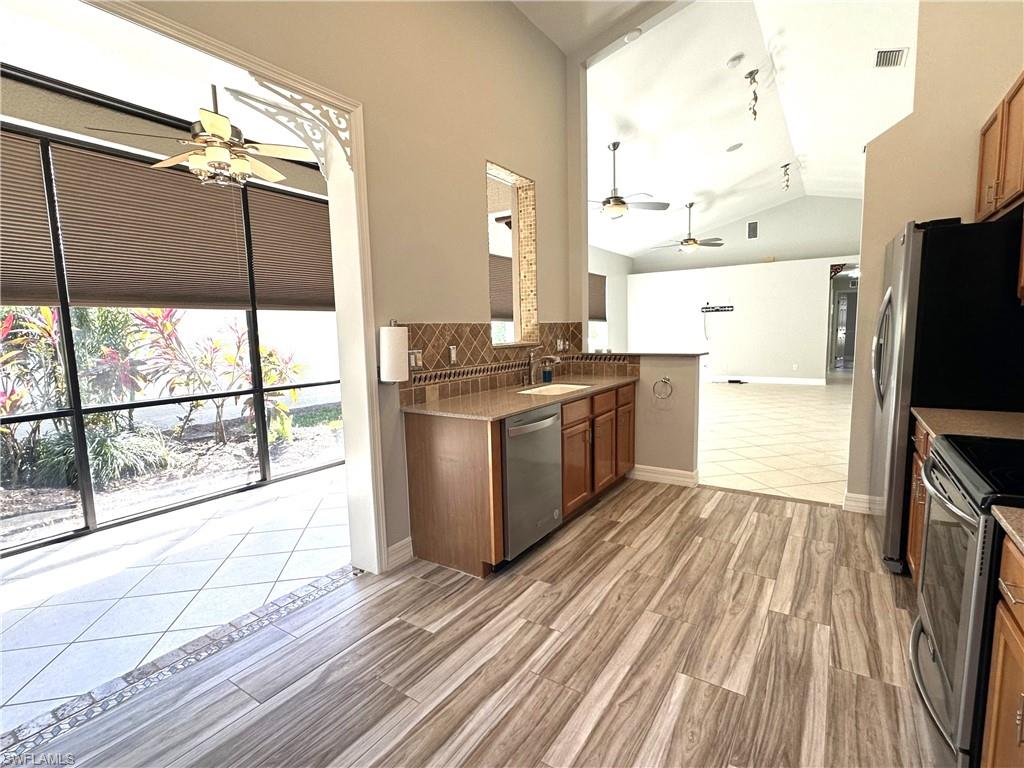 1356 Triandra Lane Naples, FL 34119 - Photo 10 of 38 a kitchen with stainless steel appliances a stove top oven a sink and cabinets