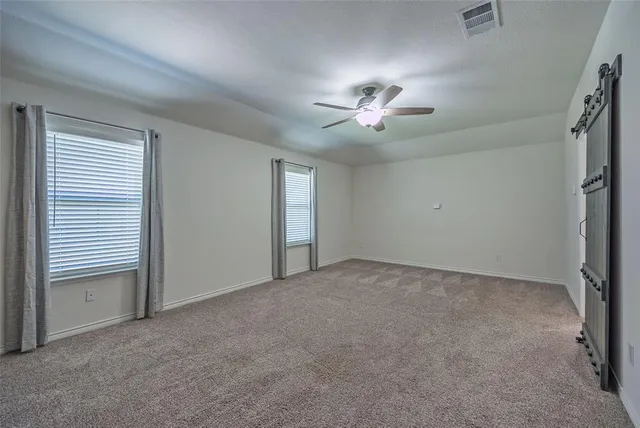 a view of an empty room with a chandelier fan