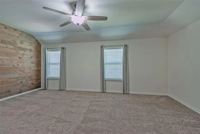 en empty room with windows and fan