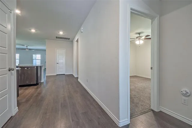 a view of a hallway with wooden floor
